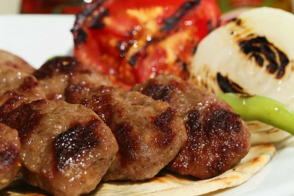 Grilled Turkish köfte with charred tomato and pepper