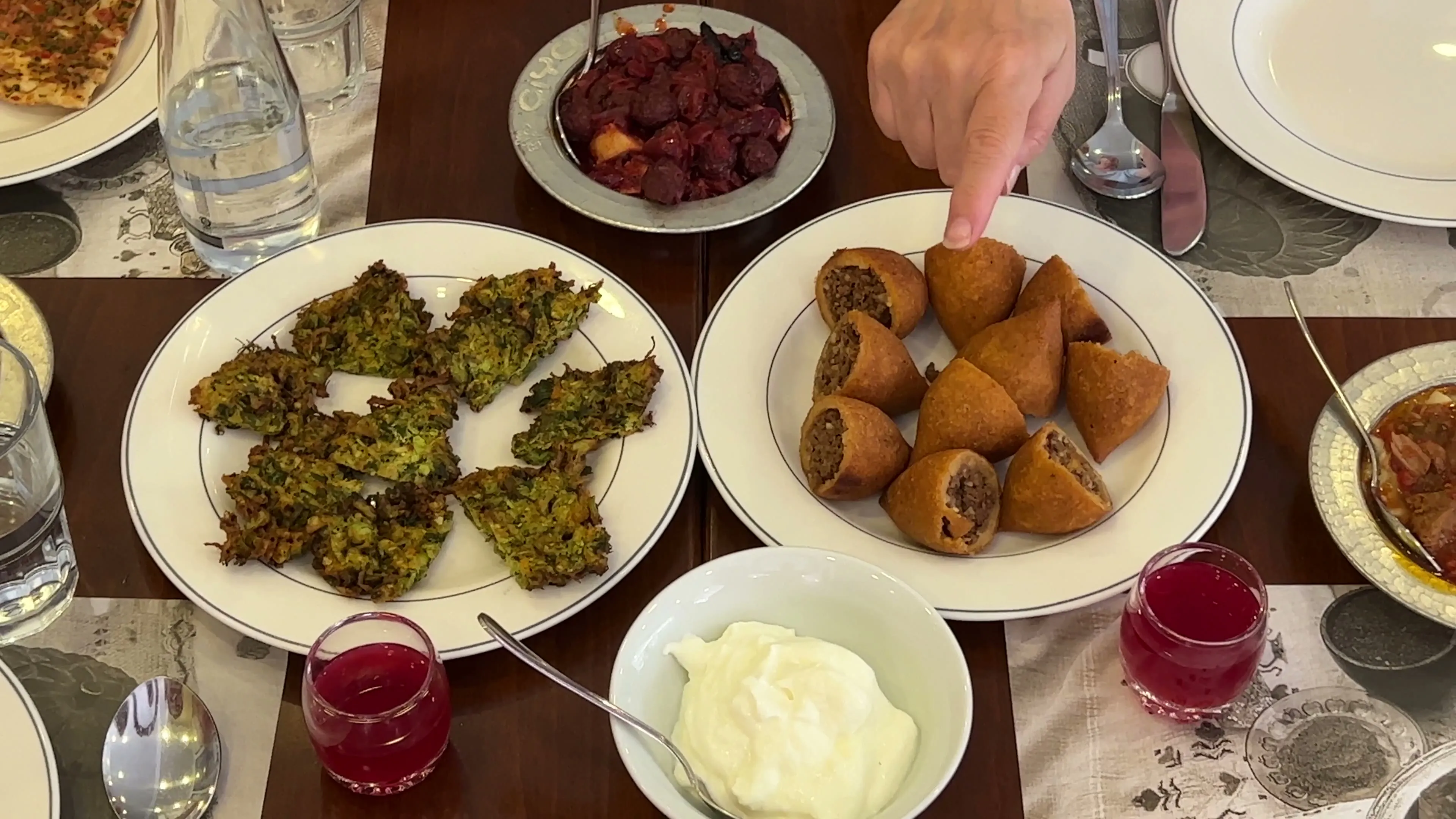 Small plates of içli köfte, greens, yogurt, and other regional dishes on a restaurant table