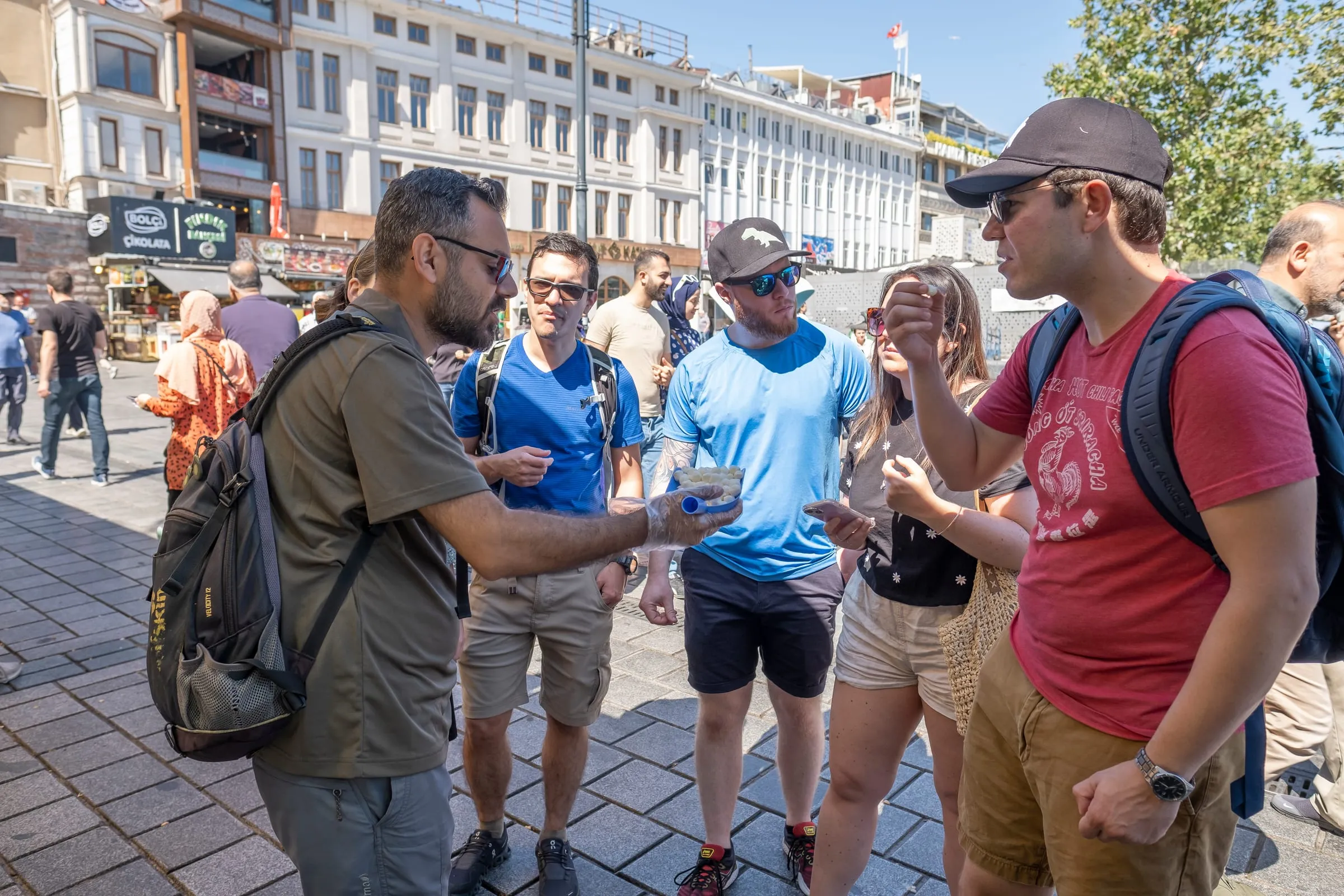 Food tour guide handing out tastings to a small group of guests in Eminönü, Istanbul