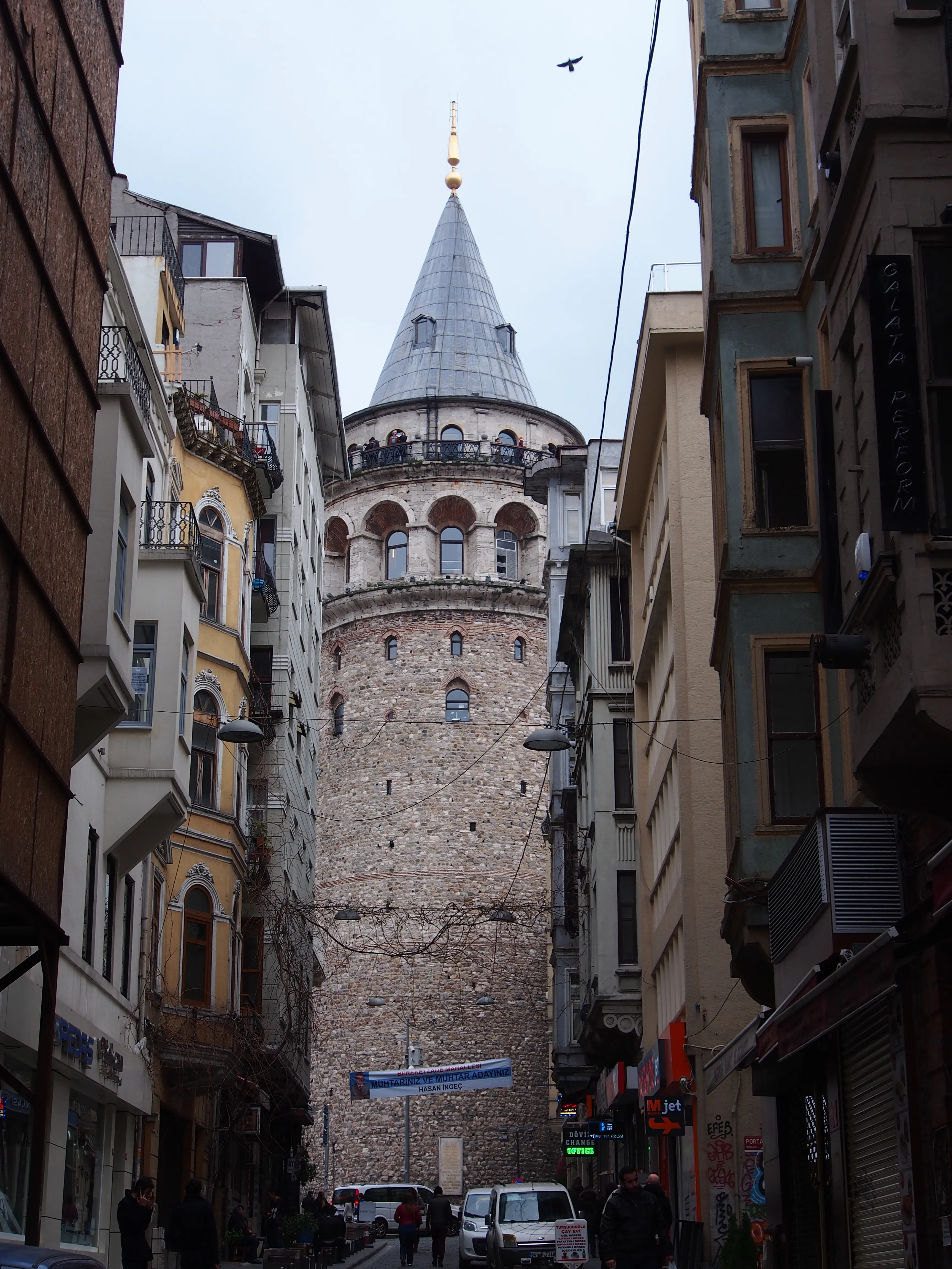 Galata Tower at the end of a narrow street rising between old buildings