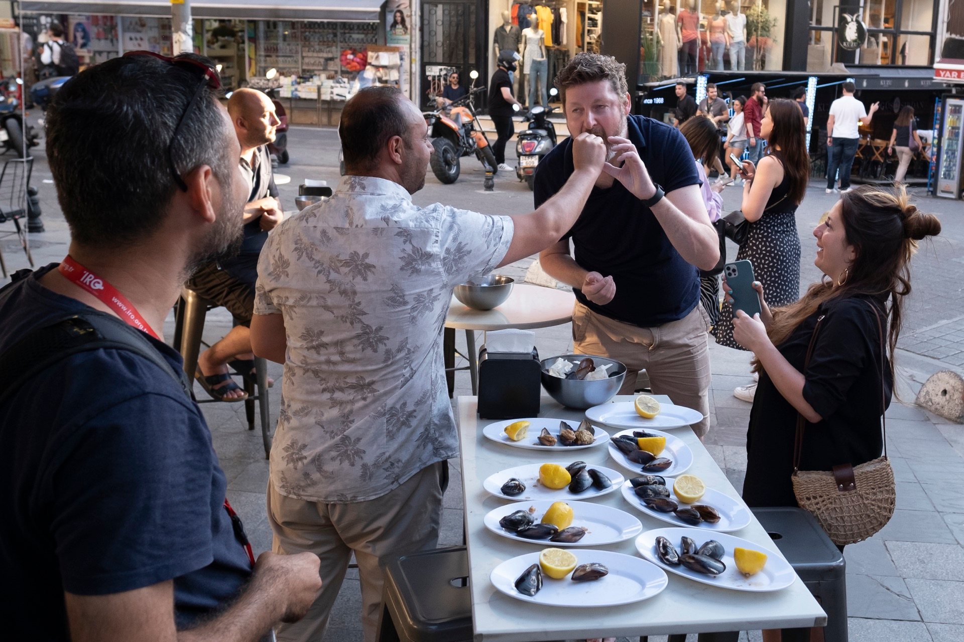group eating stuffed mussels street table