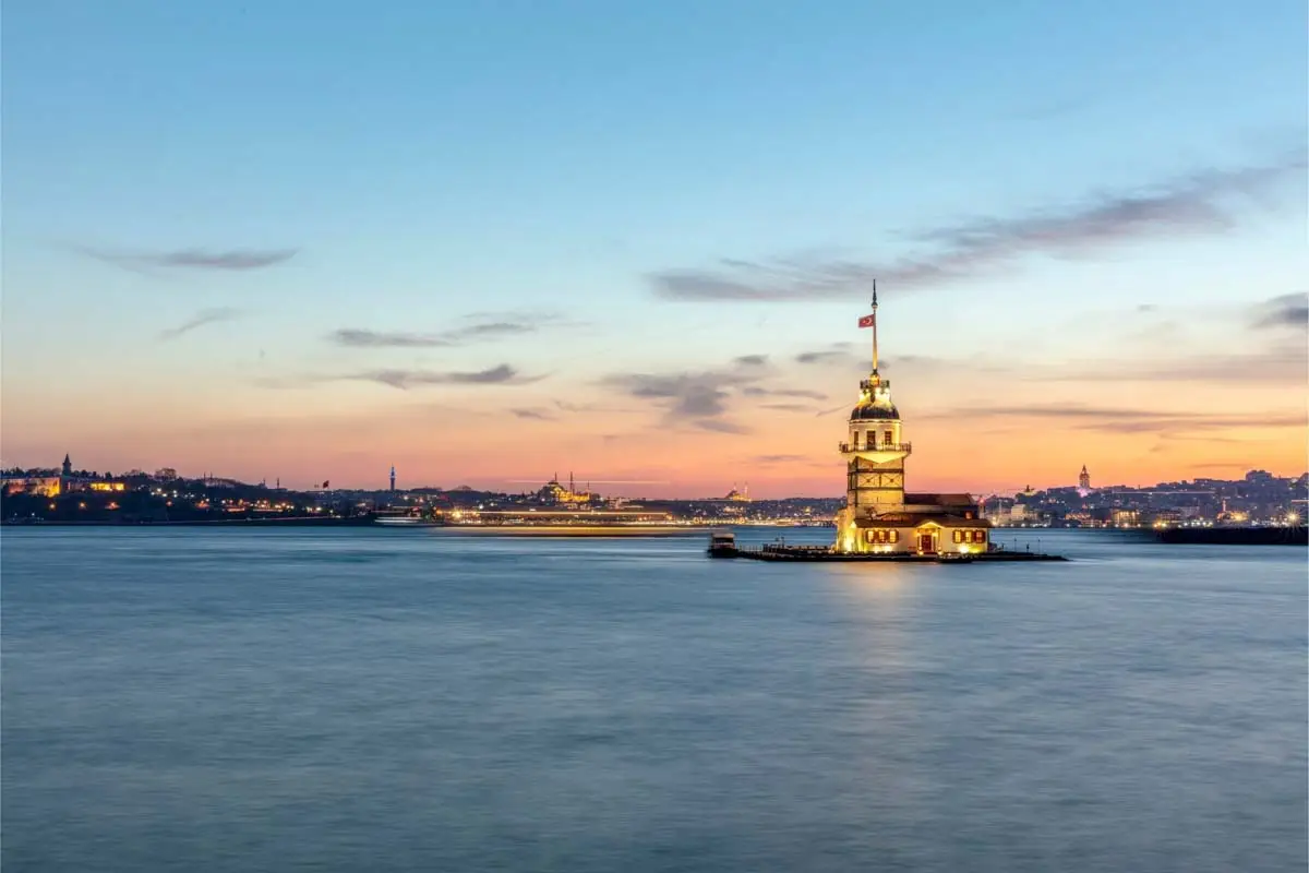 The lit Maiden's Tower on its island in the Bosphorus at dusk, Istanbul skyline behind