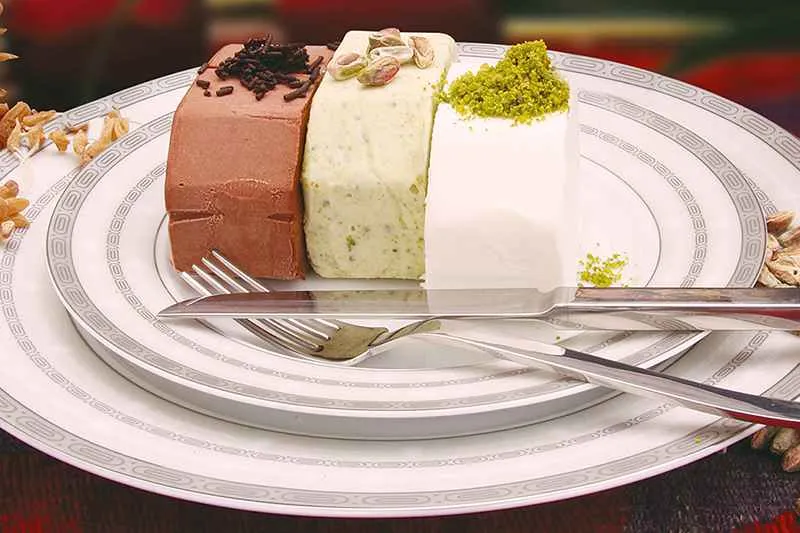 Cacao, plain and pistachio flavored Turkish ice-cream on plate with knife and fork