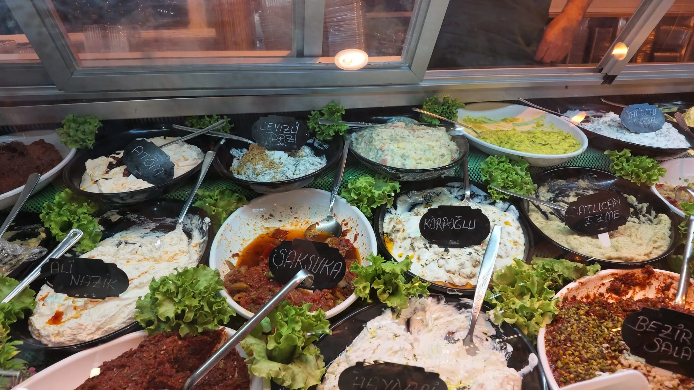 Bowls and trays of colorful meze in a chilled counter at Gözde Şarküteri in Kadıköy Market