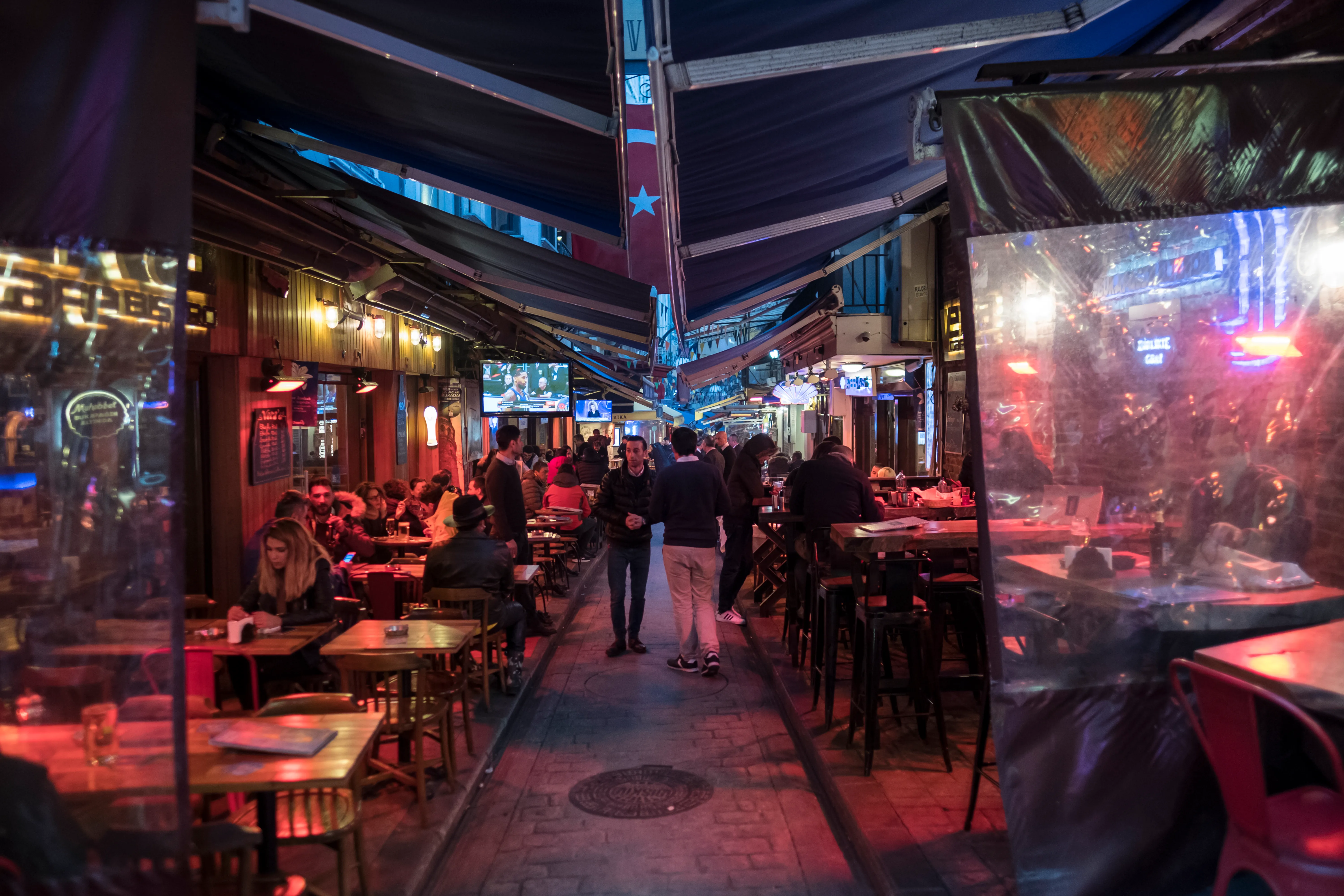 A busy Istanbul restaurant street at night with closely packed outdoor tables