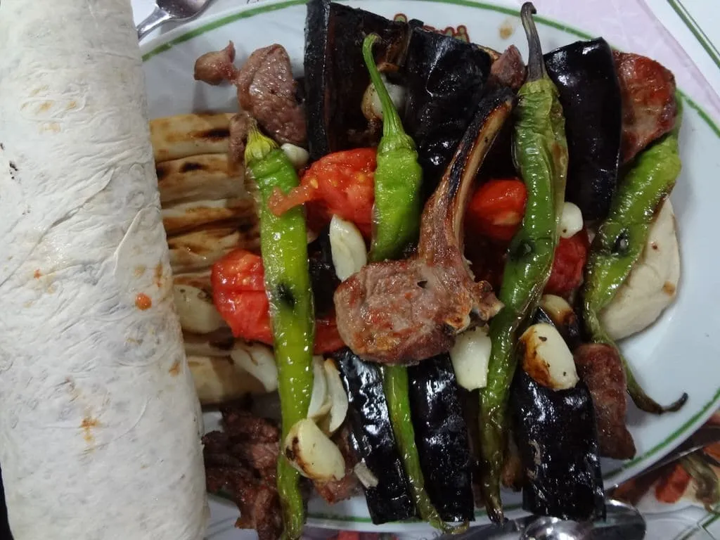 Mixed kebab plate of shish kebab, grilled lamb cutlets, roasted vegetables and garlic under flat bread