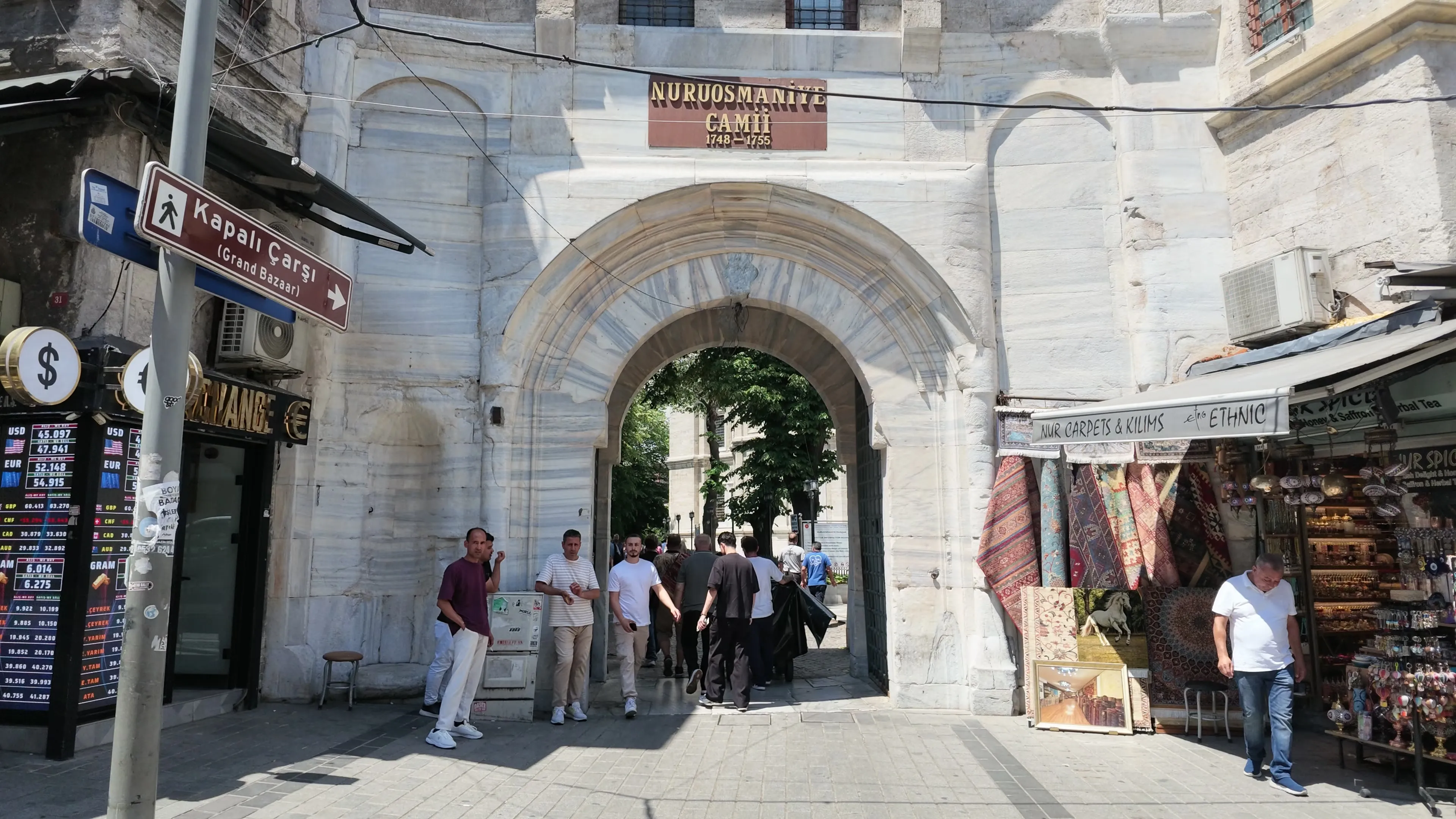 The Nuruosmaniye Mosque gate beside a sign pointing toward the Grand Bazaar