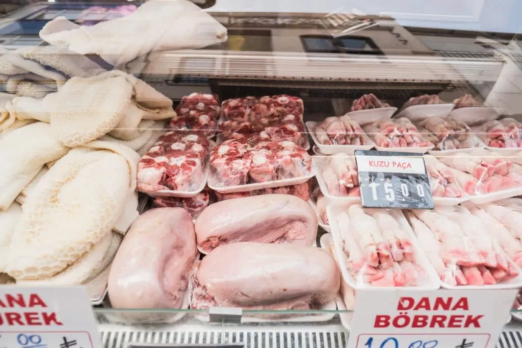 Tripe, tongue, tail, trotter offal meats on display at local butcher shop, kadikoy street food tour