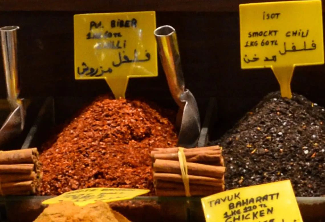 Yellow price sign reading pul biber over a mound of red pepper flakes at the Spice Bazaar