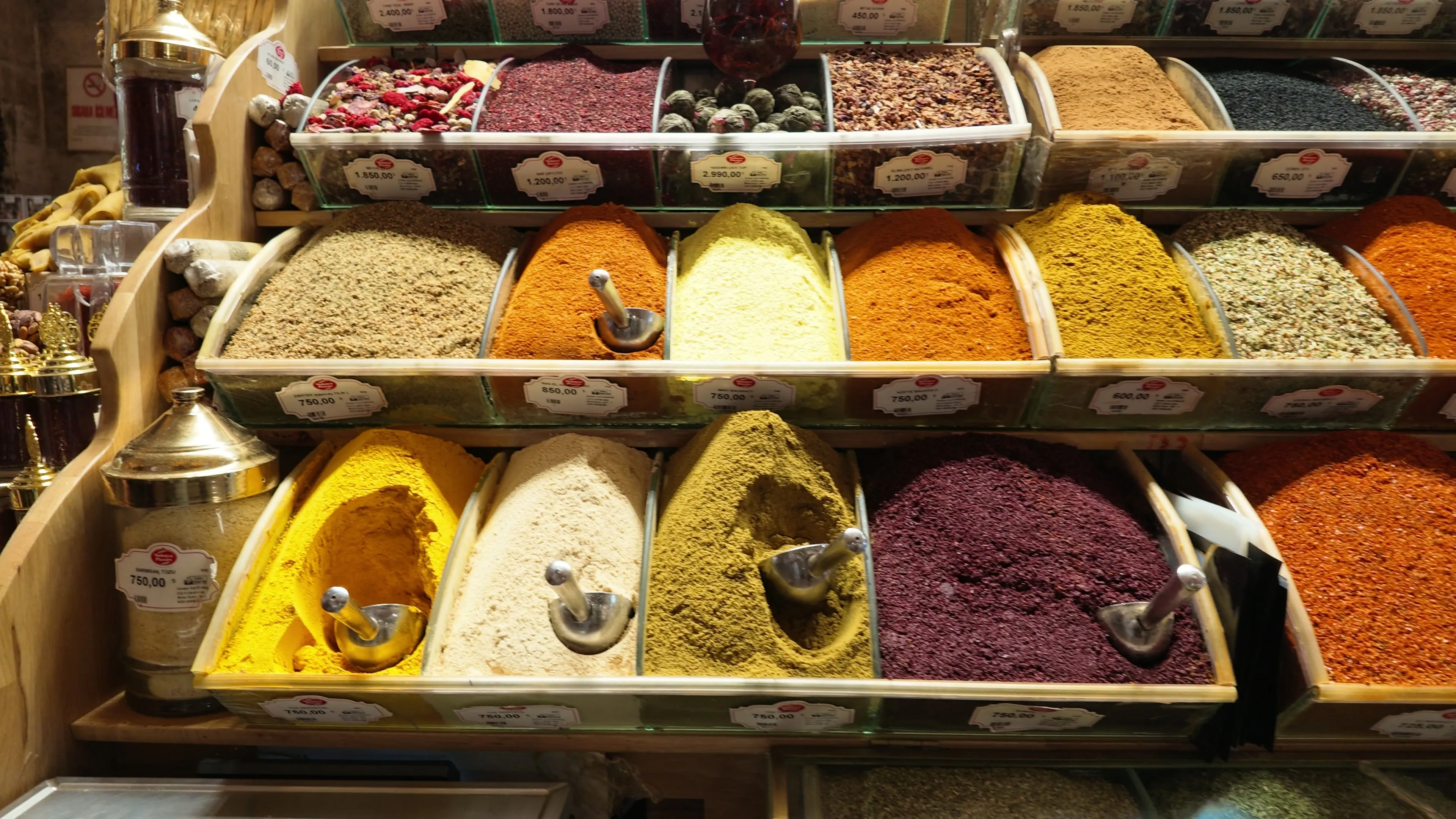 Colorful ground spices, seeds, and dried ingredients arranged in open market bins