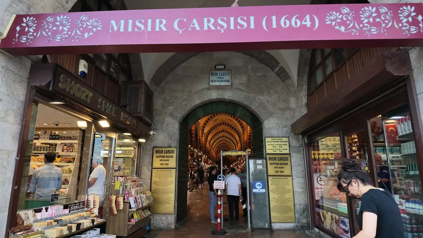 the historic stone arch entrance to Mısır Çarşısı, the Spice Bazaar, with shops on either side