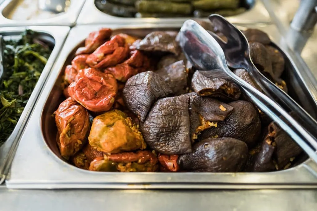 Dried eggplant and capsicum dolma in silver bain-marie tray with tongs at local restaurant, Istanbul food tour