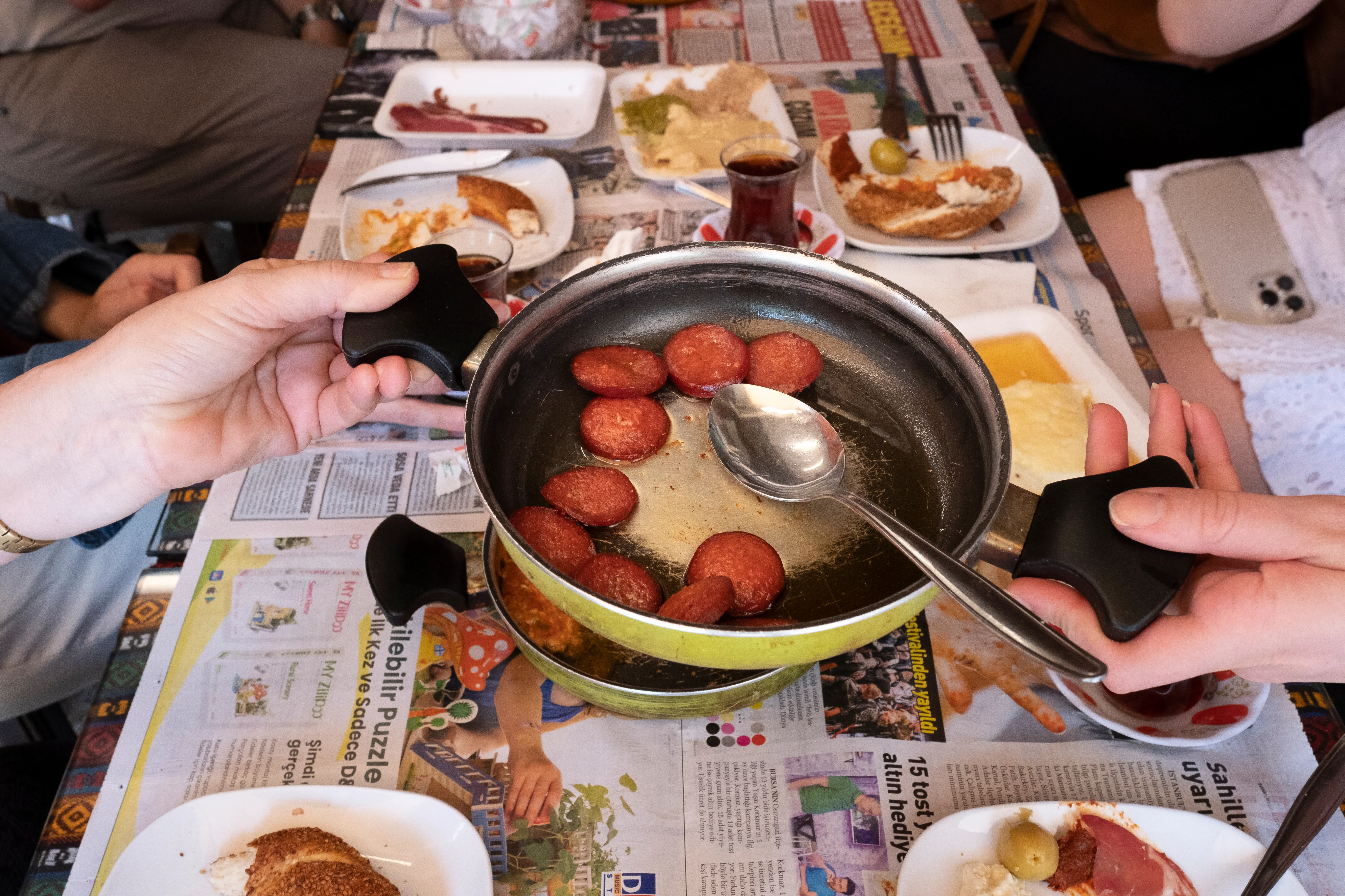 Sliced sucuk sausage served in a shallow metal pan