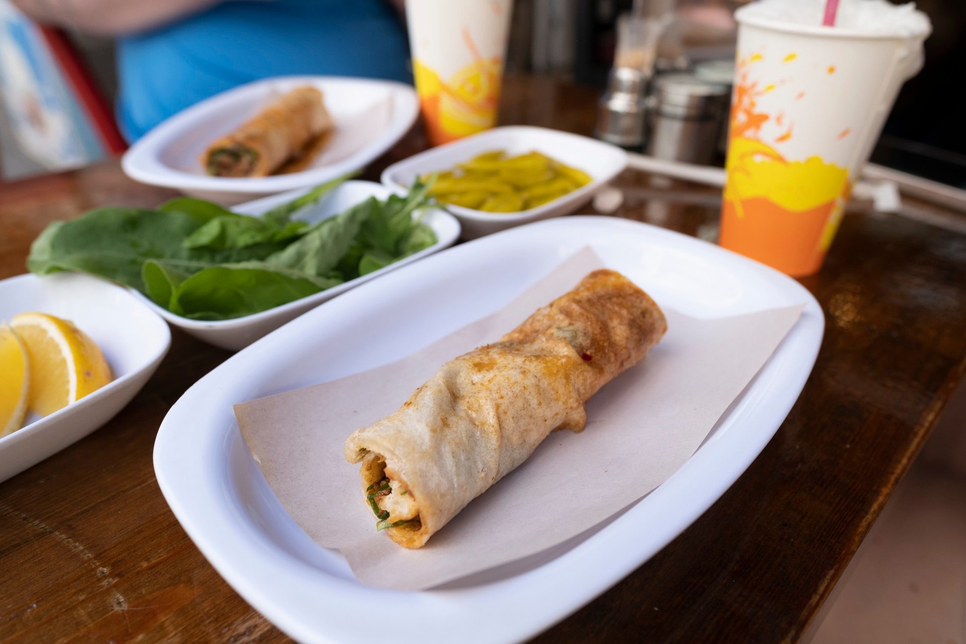 Tantuni wrap on a plate with fresh greens, pickled peppers and lemon in Istanbul