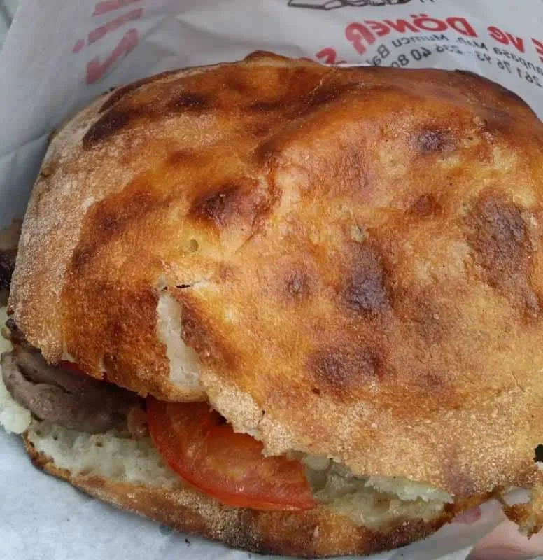 Tombik doner served in round bun-shaped pide flatbread with toppings Istanbul