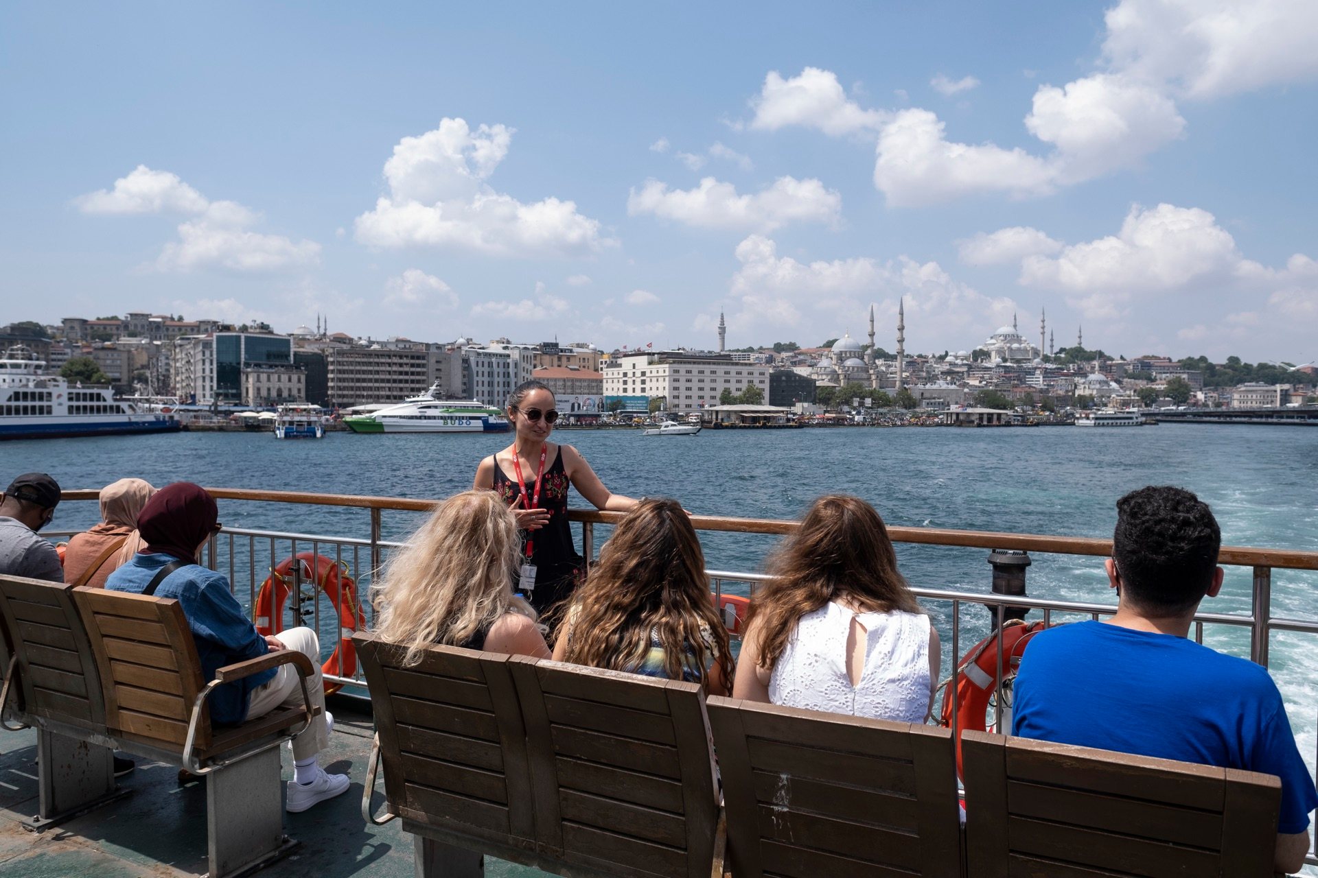 tour group seated ferry deck istanbul skyline