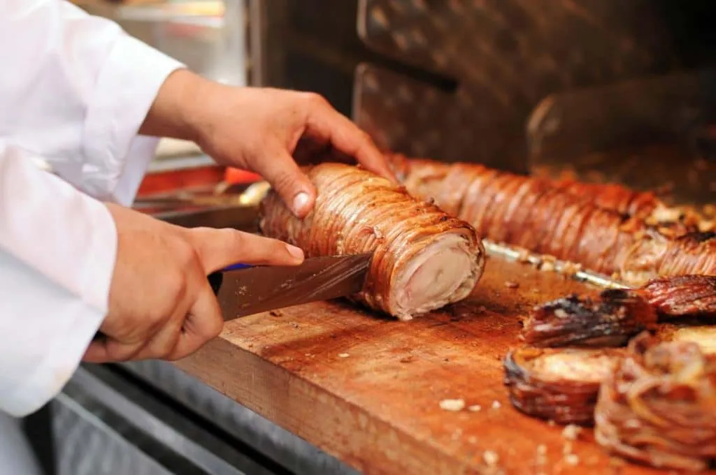 chef slicing grilled lamb intestines called kokorec which is a famous street food in Istanbul
